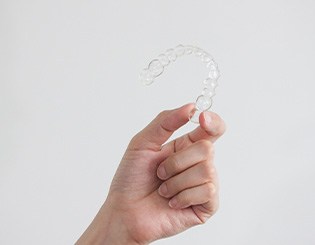Closeup of patient holding clear aligner