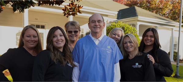 Dental team member at front desk greeting a patient