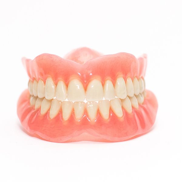 Woman smiling with dentures in Pinehurst