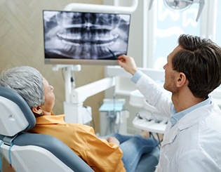a dentist explaining a patient’s X ray to them