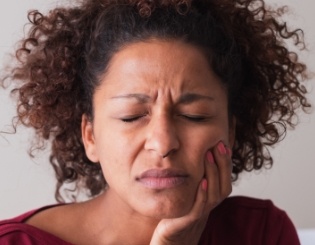 Woman with pain holding her jaw