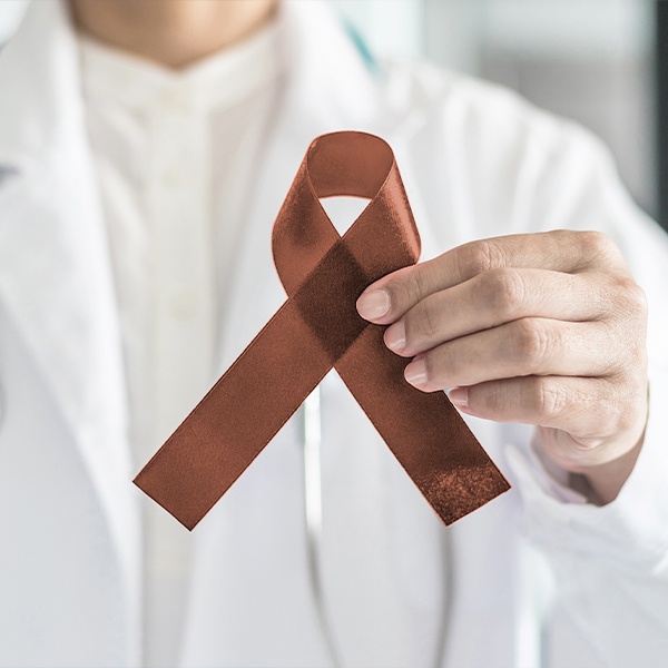 Dentist holding up an oral cancer awareness ribbon