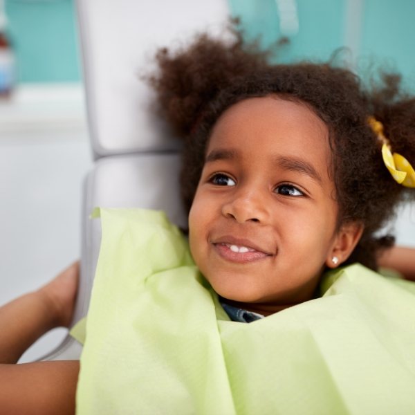 Young girl smiling after being fitted for athletic mouthguard during children's dentistry visit