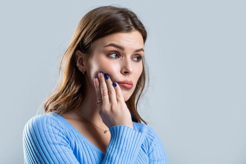 a woman experiencing tooth sensitivity in Pinehurst 