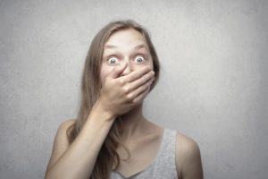Woman in shock with hand over her mouth