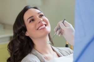 Happy female patient in dentist’s chair