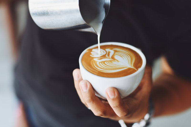 A hand holding a cup of coffee