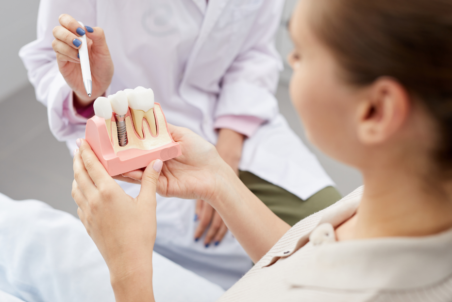 Dentist showing patient model of a dental implant
